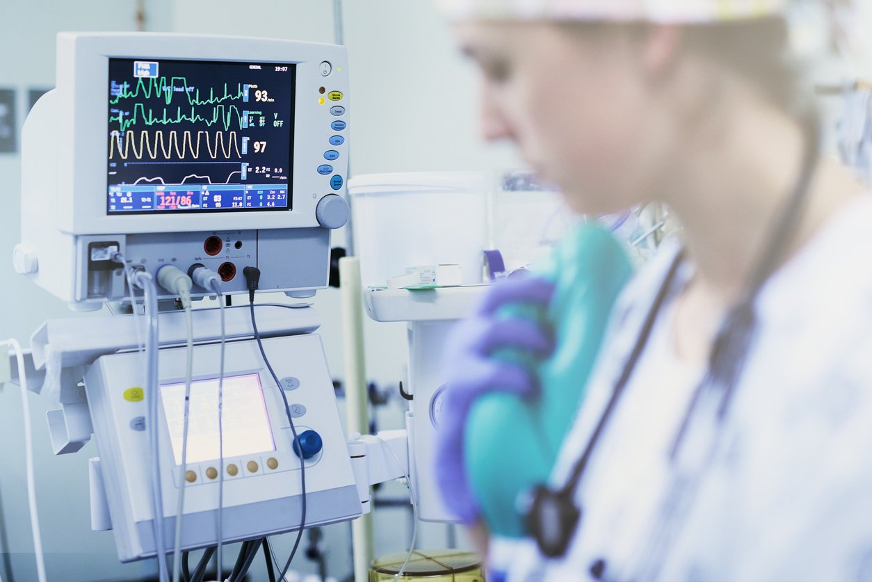 nurse in patient room with heart rate monitor