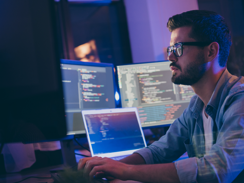 A man using multiple computer monitors