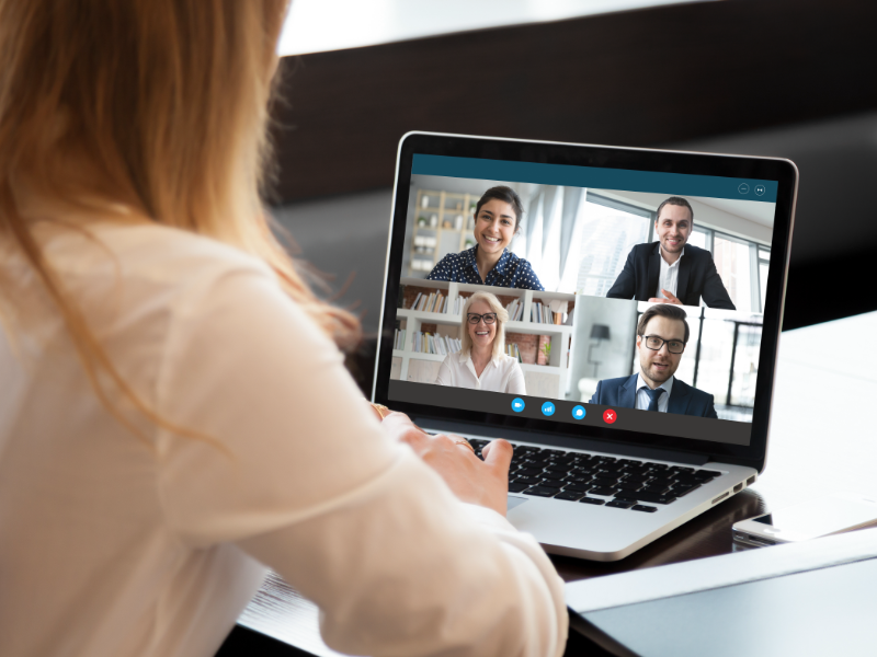 A woman on a video conference call with 4 other people